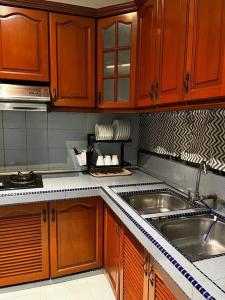 - une cuisine avec des placards en bois et un évier dans l'établissement Manjung Modern + Cozy Terrace Home, à Lumut