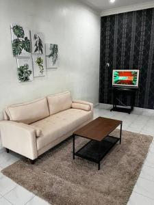 - un salon avec un canapé, une table et une télévision dans l'établissement Manjung Modern + Cozy Terrace Home, à Lumut