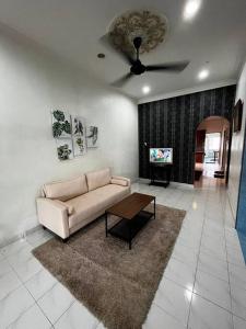uma sala de estar com um sofá e uma ventoinha de tecto em Manjung Modern + Cozy Terrace Home em Lumut