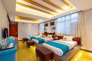 丽江Frida's Inn 丽江梦之旅观景客栈的有两张床和一台电视的酒店房间