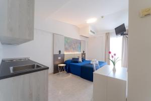 a kitchen and a living room with a blue couch at Hotel Beach in Tortoreto Lido