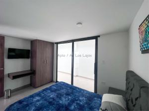 a bedroom with a bed and a large window at Apto Av Las Lajas in Ipiales