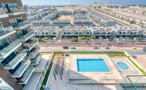 an aerial view of a building with a swimming pool at Pacific 1BR at Azizi Samia Jebel Ali by Deluxe Holiday Homes in Dubai