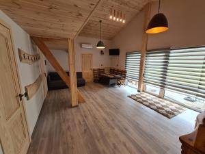 a living room with wooden floors and wooden ceilings at Priedes in Engure