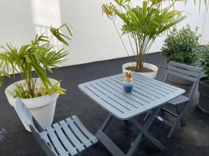a blue picnic table and two chairs and plants at Studio le petit écureuil in Carnac