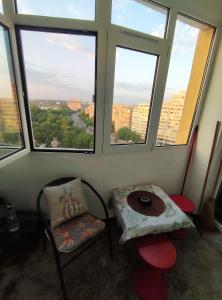 Habitación con silla, mesa y ventanas en Lake and park view residence en Bucarest