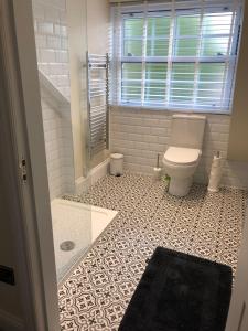 a bathroom with a toilet and a tile floor at Kirkcudbright Holiday Apartments - Apartment G in Kirkcudbright
