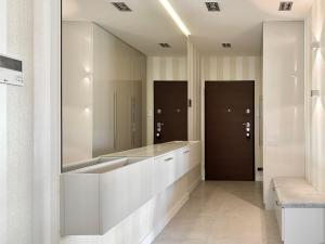 a bathroom with a large mirror and a sink at Marina Apartment Blanco in Gdańsk