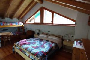 1 dormitorio con 1 cama en una habitación con ventana en Chalet Maso Salam en Bocenago