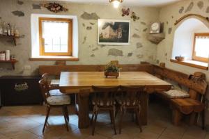 comedor con mesa de madera y sillas en Chalet Maso Salam en Bocenago