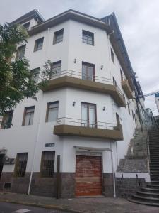 - un bâtiment blanc avec une porte et un balcon dans l'établissement LACASADELCORONEL, à Quito