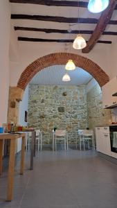 a kitchen with a stone wall and tables and chairs at Affittacamere Garibaldi in Alcamo