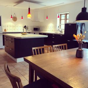 a large kitchen with a wooden table and chairs at Gården på Bakken in Holme-Olstrup