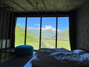 una camera con letto e vista sulle montagne di Gzaze a Kazbegi
