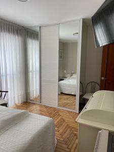 - une chambre avec un miroir, un lit et un bureau dans l'établissement La de Mondi, à Baiona