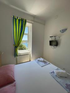 a bedroom with a large white bed with a window at Bed&Breakfast Villa Eva in Omišalj