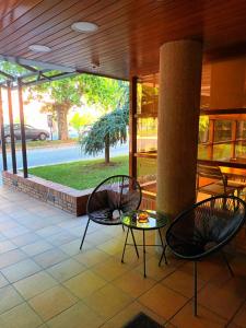 een patio met 2 stoelen, een tafel en een paal bij Hotel Estel in Berga