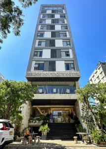 a tall building with a restaurant in front of it at Helios Boutique Hotel & Spa in Da Nang
