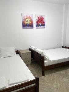 a bedroom with two beds and two pictures on the wall at Apartment Nikolay in Nea Potidaea