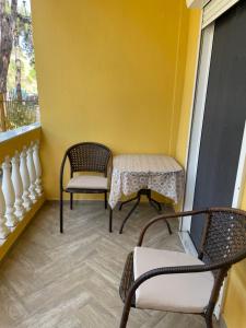 a balcony with two chairs and a table and a window at Apartment Nikolay in Nea Potidaea