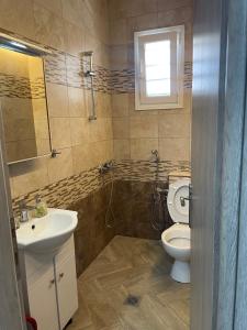 a bathroom with a sink and a toilet and a window at Apartment Nikolay in Nea Potidaea