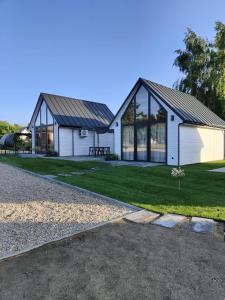 a white house with a gambrel roof at Morska Szyszka & Leśne SPA in Odargowo