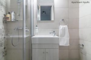 a white bathroom with a sink and a shower at Apollo & Artemis by Heloni Apartments in Athens