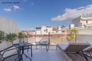 a patio with chairs and tables on a balcony at Apollo & Artemis by Heloni Apartments in Athens