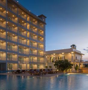 a hotel with a swimming pool in front of a building at Chanalai Hillside Resort, Karon Beach in Karon Beach