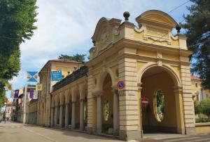 a yellow building with an archway on a street at B&B LeTerrazze Boutique Hotel - Torino in Ciriè
