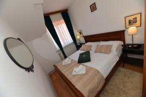 a bedroom with a bed with a mirror on the wall at Apartmani Lucija in Ludbreg