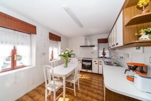 a kitchen with a white table and chairs in a kitchen at Altamira, SEA & MOUNTAIN in Busturia