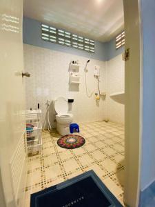 baño con aseo y suelo de baldosa. en Shaman's apartment at Ya Nui beach en Phuket