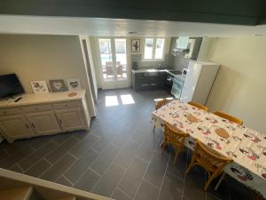 eine Küche mit einem Tisch und Stühlen sowie eine Küche mit einem Tisch und einem Kühlschrank in der Unterkunft Jolie maison avec piscine in Rochefort-du-Gard