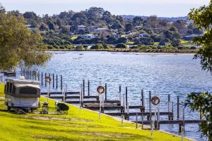 a rv parked at a dock next to a lake at Mallacoota Hotel Motel in Mallacoota