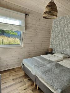 um quarto com uma cama e uma janela em Morska Szyszka & Leśne SPA em Odargowo