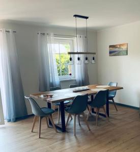 a dining room table and chairs in a room at Naturstrand Apartment - 86m² - 4 Betten - Parkplatz in Hagermarsch
