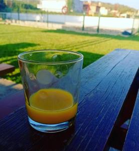 un vaso de zumo de naranja sentado en una mesa de madera en CAL RUSC ALLOTJAMENT RURAL en Crespiá