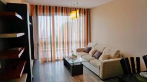 uma sala de estar com um sofá e uma mesa de vidro em Апартамент Балчик Гардънс - Balchik Gardens Apartment em Balchik