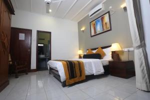 a bedroom with a large bed with white sheets at Villa Velmarie Yoga and Ayurveda house all inclusive in Beruwala
