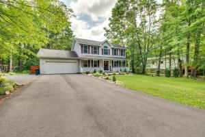 una casa blanca con garaje en una entrada en Pocono Summit Home with Game Room, 3 Mi to Kalahari!, en Pocono Summit