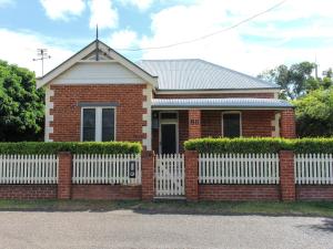 a red brick house with a white fence at Family Retreat East Tamworth in Tamworth