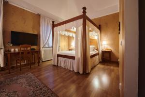 a bedroom with a canopy bed and a desk at Hotell Läckö in Lidköping