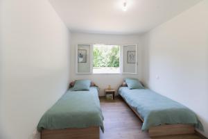 - 2 lits dans une chambre avec fenêtre dans l'établissement Villa Graveyron - Maison avec piscine privée, à Berrias Et Casteljau
