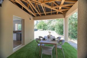 une salle à manger avec une table et des chaises sur gazon dans l'établissement Villa Graveyron - Maison avec piscine privée, à Berrias Et Casteljau