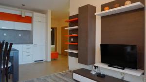 a living room with a tv and a kitchen at Апартамент Балчик Гардънс - Balchik Gardens Apartment in Balchik