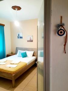 a bedroom with a bed with blue pillows at Think Blue Apartment in Nea Vrasna in Asprovalta