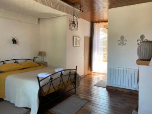 1 dormitorio con 1 cama y pasillo con ventana en GITE de GROUPE Le Domaine de Maumont, en Milhac-de-Nontron