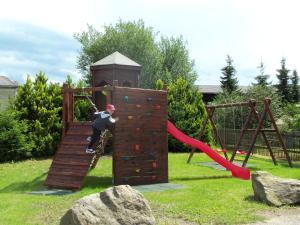a young boy is climbing on a playground equipment at Ferienpension Gabriele in Kurort Gohrisch