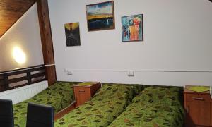 a bedroom with a bed and some pictures on the wall at Suwałki Centrum Studio in Suwałki